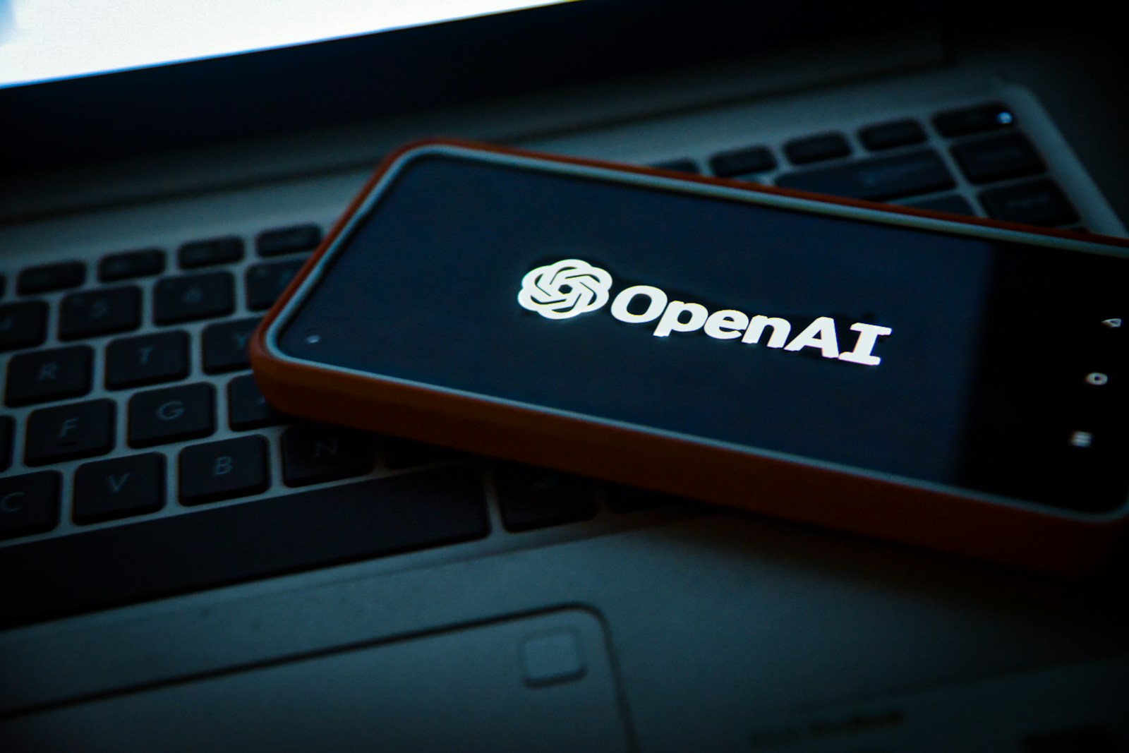 a cell phone sitting on top of a laptop computer - ChatGPT