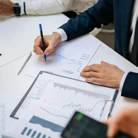 A Guide To Collective Investment Schemes - Professionals analyzing financial charts in a corporate setting.