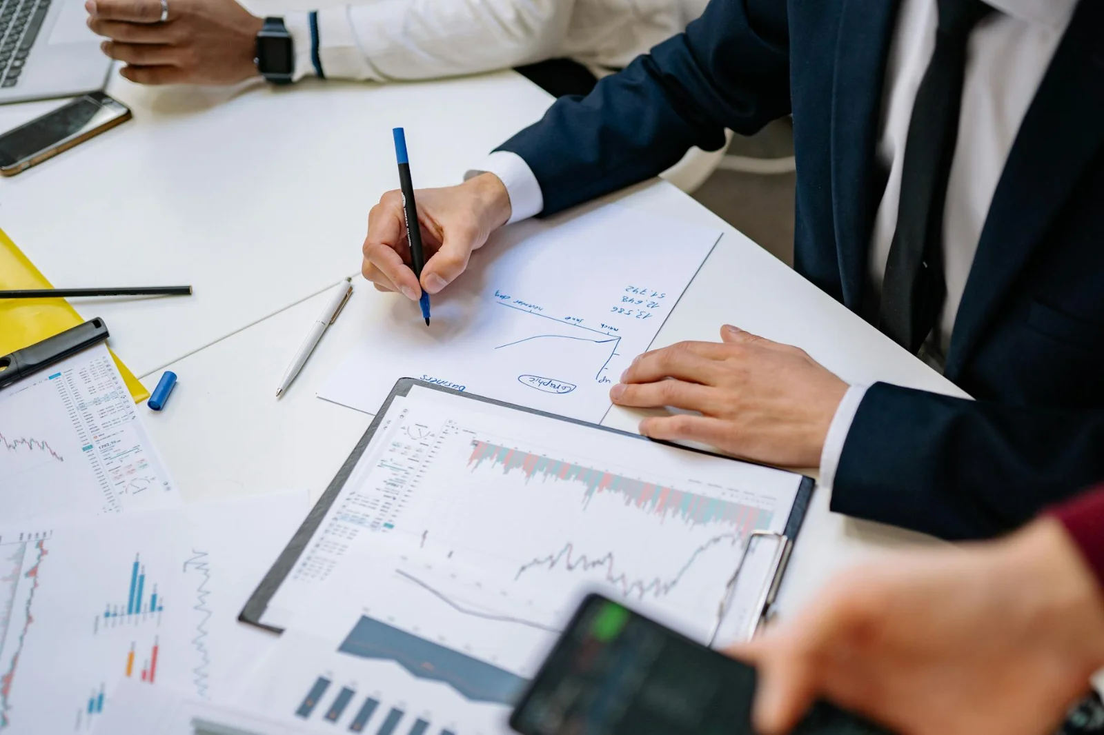 A Guide To Collective Investment Schemes - Professionals analyzing financial charts in a corporate setting.