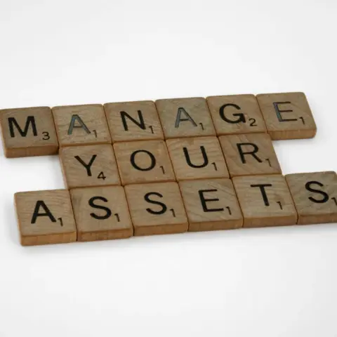 Cross-Border Estate Planning for UAE Expats - Wooden tiles spelling 'Manage Your Assets' offer conceptual business advice.